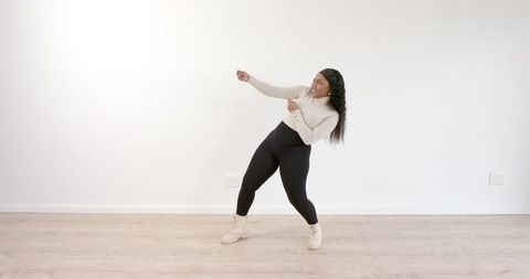 Woman Cheerfully Dancing in Spacious Living Room Setting