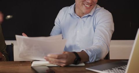 Smiling professional reviewing documents in office meeting