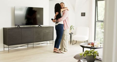 Happy couple celebrating engagement at home with gift