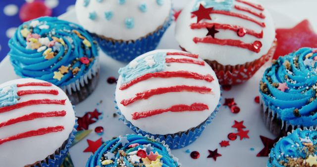 A selection of patriotic-themed cupcakes decorated in red, white, and blue, with stars and stripes, perfect for an American holiday celebration. These festive desserts are ideal for events like the Fourth of July or Memorial Day gatherings.
