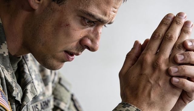 Closeup u.s. Army soldier clasping hands and crying reflecting on service and sacrifice