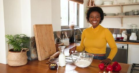 Smiling Woman Baking in Rustic Kitchen with Natural Light