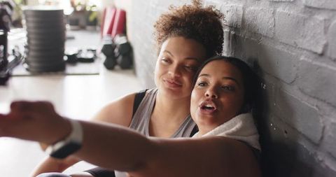 African american women resting and smiling after workout, gym camaraderie and wellness