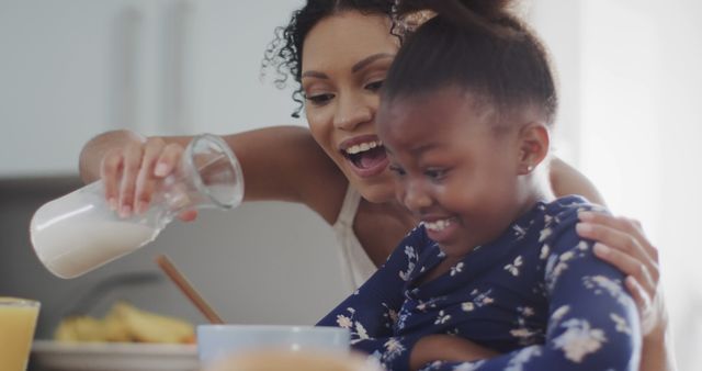 Loving Mother Pouring Milk for Laughing Daughter During Breakfast - Download Free Stock Images Pikwizard.com