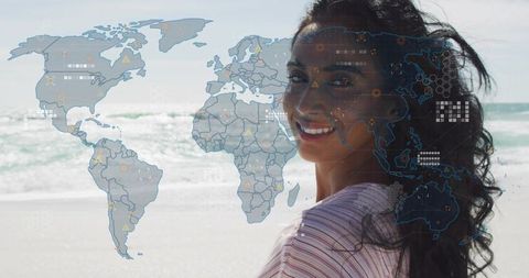 Smiling traveler turning toward camera on sunlit beach with translucent world map overlay