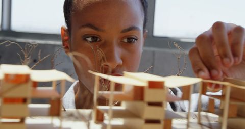 Focused Businesswoman Analyzing Architectural Model in Modern Office