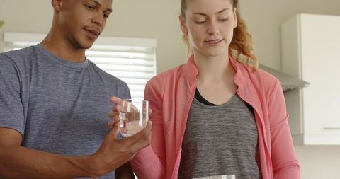 Young couple preparing morning drink at kitchen counter sharing casual home moment