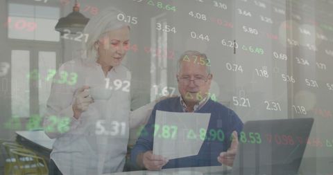 Senior couple analyzing finances with laptop and financial data