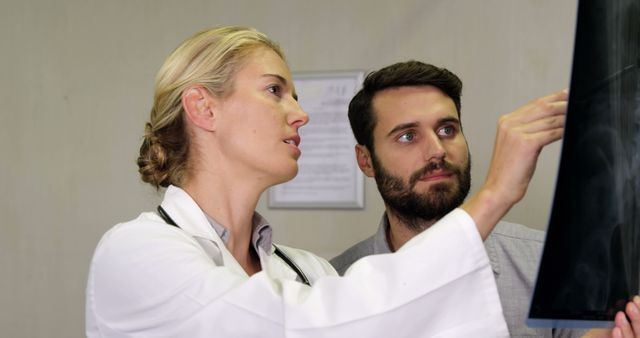 Doctor Explaining X-Ray to Young Man in Medical Office - Download Free Stock Images Pikwizard.com