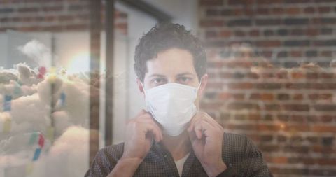 Worker wearing mask with conceptual cloud imagery, office safety