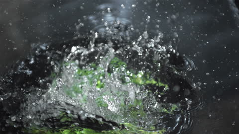 Fresh Asparagus Splashing into Water Creating Abstract Patterns