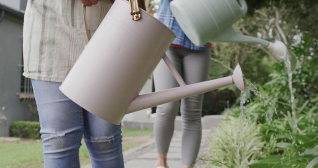 People Watering Plants in Backyard Garden with Watering Cans - Download Free Stock Images Pikwizard.com