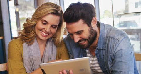 Smiling Couple Using Tablet in Cozy Café Setting - Download Free Stock Images Pikwizard.com