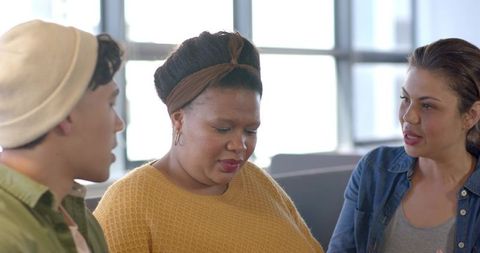 Diverse team discussing project in bright coworking lounge, casual collaboration