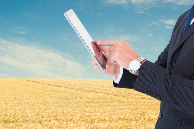 Midsection of businessman using tablet PC at farm - Download Free Stock Photos Pikwizard.com