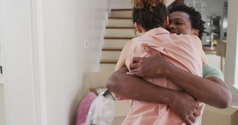 Joyful biracial couple embracing in newly acquired home