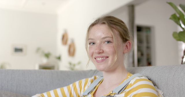 Smiling Young Woman Relaxing on Comfortable Sofa in Modern Living Room - Download Free Stock Images Pikwizard.com