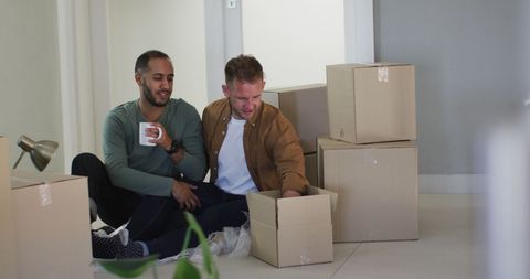 Same-Sex Couple Enjoying Coffee While Packing Moving Boxes - Download Free Stock Images Pikwizard.com