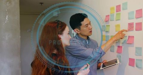 Collaborative brainstorming with sticky notes and tablet in modern office workspace