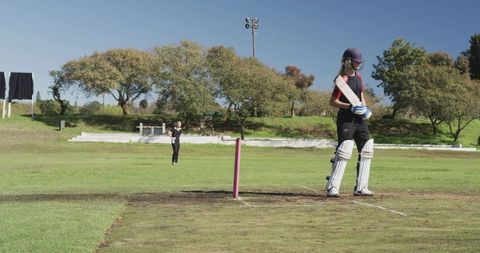 Female Cricket Player Batting on Sunny Sports Field