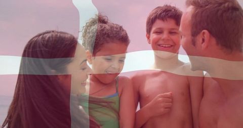 Smiling family on danish beach with flag overlay celebrating summer together