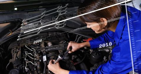 Female Mechanic Repairing Car Engine with Ratchet and Digital Diagnostics Overlay