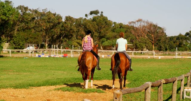 Two riders, in their young adult years, are enjoying a leisurely horseback ride along a scenic trail, with copy space. Their relaxed posture and the tranquil outdoor setting suggest a peaceful recreational activity.