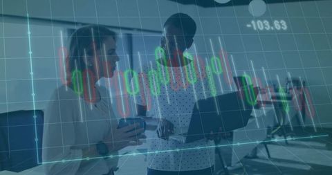 Two female coworkers analyzing stock charts on laptop in modern office