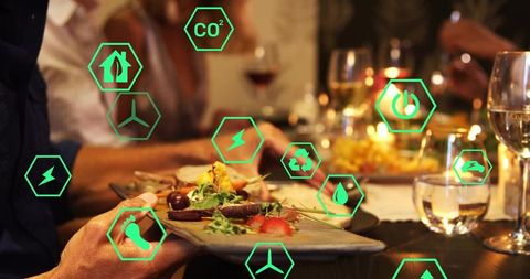 Sustainable dining experience with digital eco icons overlaying candlelit restaurant scene