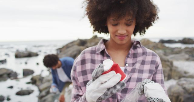 Young Woman Collecting Trash on Rocky Beach - Download Free Stock Images Pikwizard.com