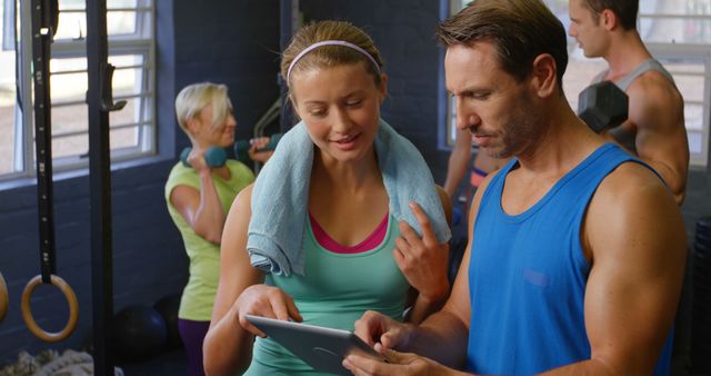 Personal Trainer Guiding Female Client on Tablet - Download Free Stock Images Pikwizard.com