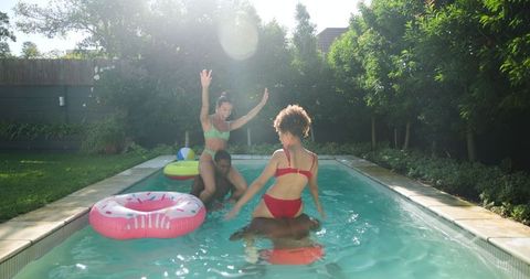 Diverse Friends Enjoying Refreshing Fun in Backyard Pool