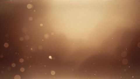Glowing sepia bokeh background spreading soft light with floating dust and warm orbs