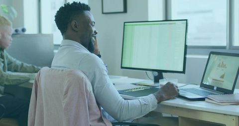 Professional Worker Analyzing Data on Monitor in Open Office Setup