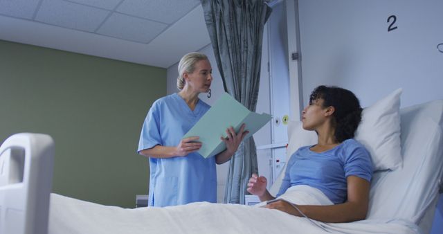 Diverse female doctor talking to patient sitting in hospital bed - Download Free Stock Photos Pikwizard.com