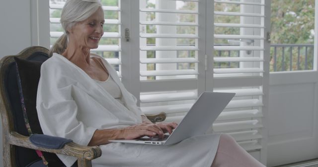 Older woman with laptop working from home in comfortable chair - Download Free Stock Images Pikwizard.com