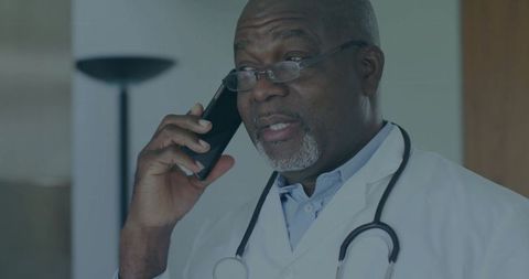 Doctor Consulting Over Phone with Stethoscope in Clinic