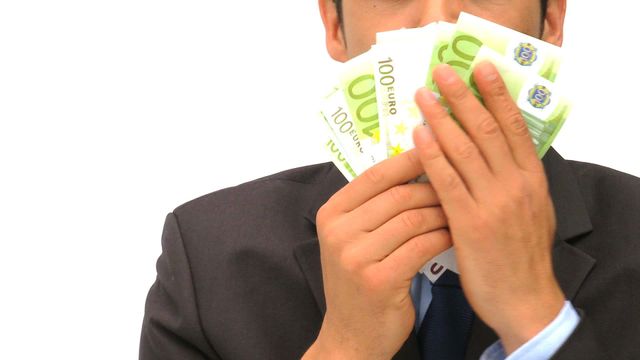 Young businessman celebrating financial success by holding and kissing 100 euro notes close to his face. Captures themes of wealth and happiness in a professional setting. Perfect for financial and banking industry marketing, economic growth illustrations, and success-focused campaigns.