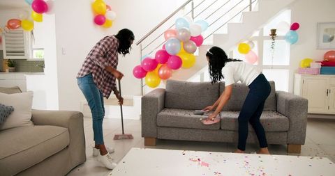 Women Cleaning Living Room After Celebration