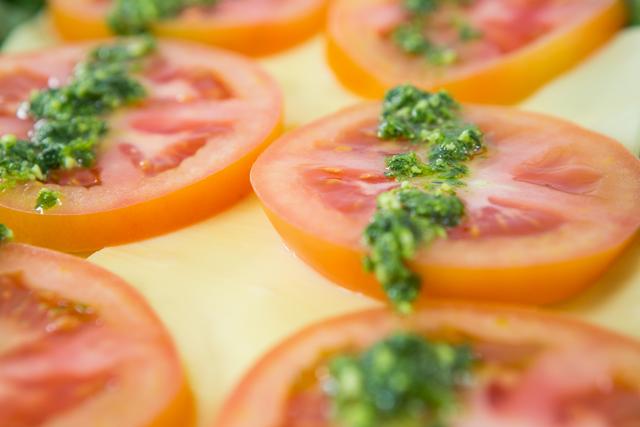 Close-up of tomato slices garnished with green chutney in salad