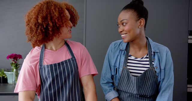 Two Friends Wearing Aprons Smiling in Modern Kitchen - Download Free Stock Images Pikwizard.com