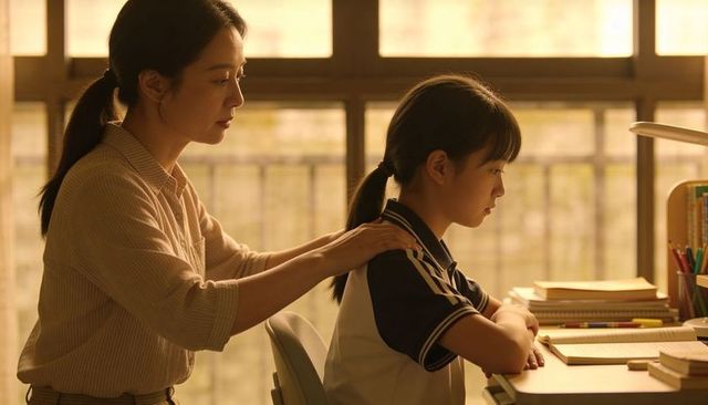 Mother reassuring daughter while studying at desk in warm golden sunlight promoting focus