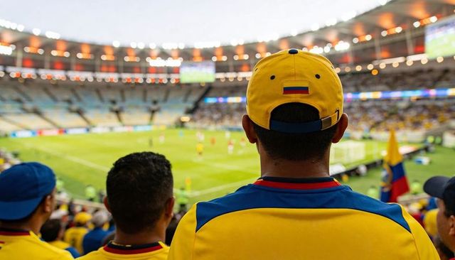 Cheering colombian soccer fan wearing yellow jersey and cap with flag patch in stadium