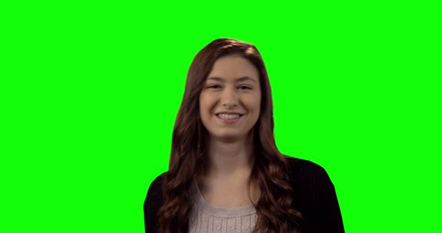 Young woman with long brown hair smiling in front of a green screen background. Image can be used for various editing purposes such as adding different backgrounds and themes. Ideal for advertisements, promotional material, and social media graphics.