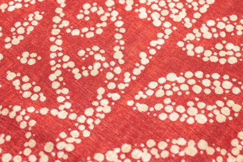 Red textile featuring organic white dot batik pattern for home decor