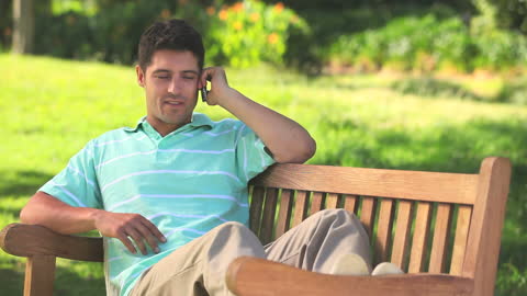Relaxed Young Man Enjoying a Phone Call in a Park