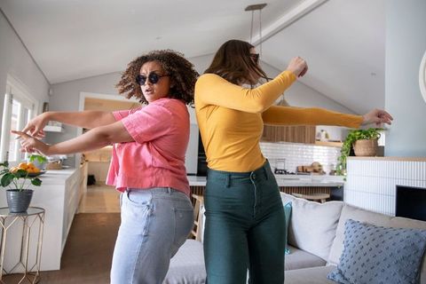 Diverse Female Friends Dancing in Modern Living Room
