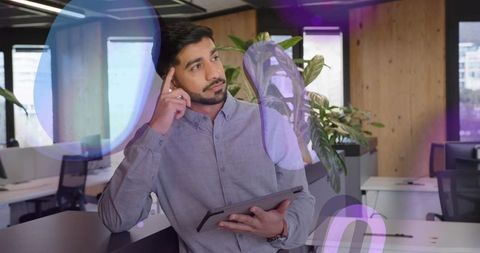Professional Man Holding Tablet in Modern Office, Contemplative Mood