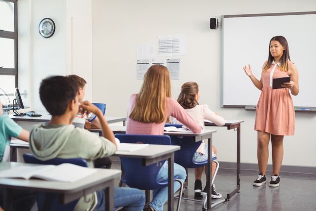 Schoolgirl giving a presentation in a classroom while other students and a teacher listen attentively. Ideal for educational content, school brochures, academic websites, and articles on public speaking and classroom activities.
