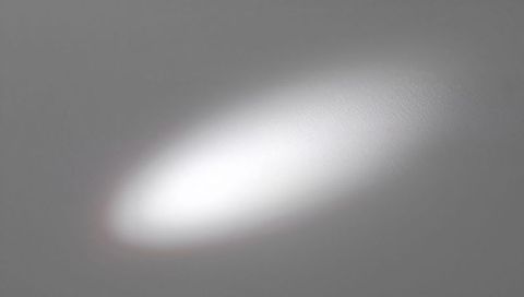 Soft Oval Spotlight Casting on Light Gray Plaster Wall with Subtle Texture